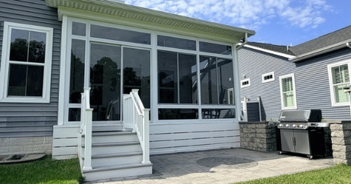 Exterior of a Coastal Club sunroom with wide windows and white steps